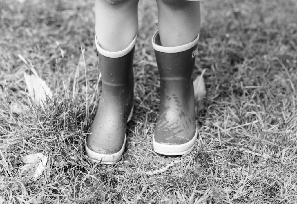 Kind met regenlaarsjes speelt buiten bij The Kids Company dagopvang in Veldhoven