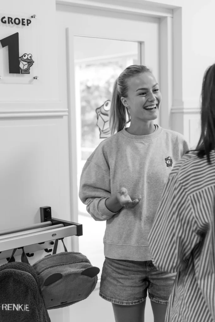 Pedagogisch medewerker in gesprek met ouder tijdens overdracht bij kinderopvang The Kids Company