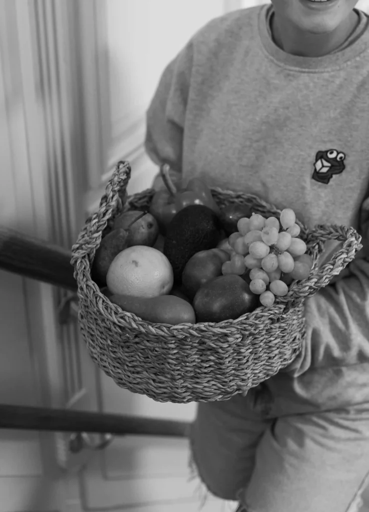 Pedagogisch medewerker met fruitmand bij The Kids Company – gezonde voeding in de kinderopvang