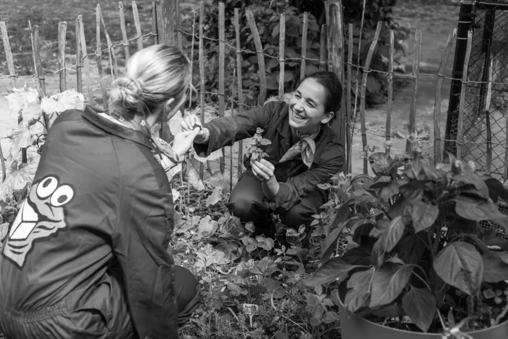 Pedagogisch medewerkers met kinderen in de moestuin van The Kids Company kinderopvang in Veldhoven